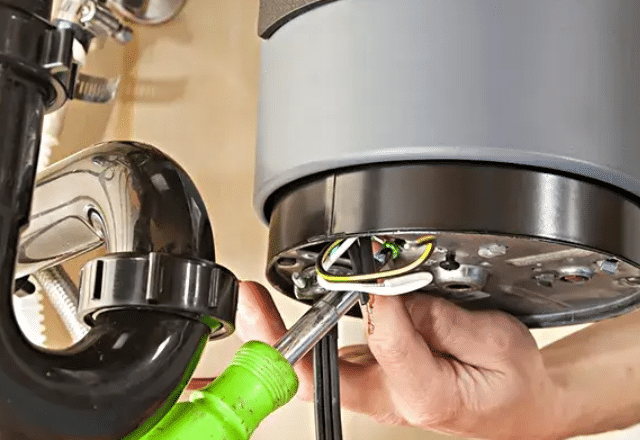 Examining and repairing electrical connections in a garbage disposal.