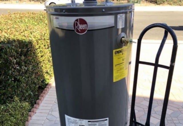 Outdoor installation of a Rheem water heater, commonly subject to the elements and requiring emergency repair services.