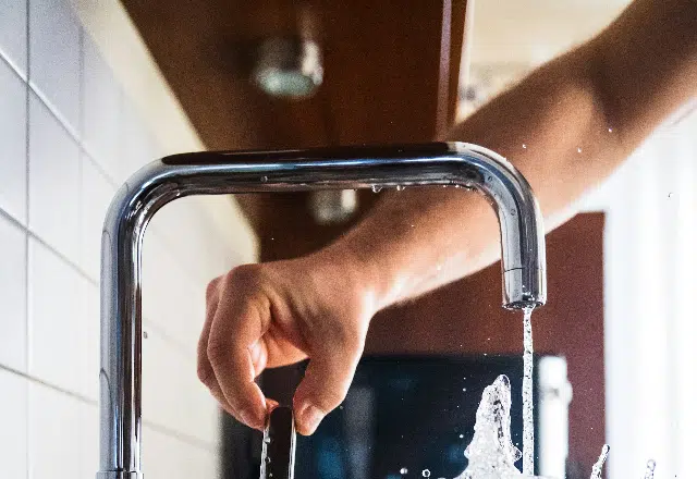 Water flowing from a chrome kitchen faucet