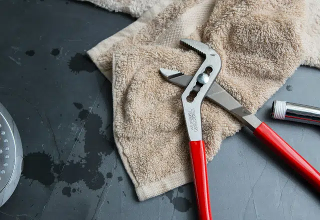 Pliers with red handles on a beige towel, with water droplets nearby, indicative of recent plumbing work, available at a Sacramento supply store