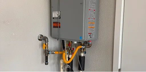 Wall-mounted tankless water heater professionally installed with copper and gas piping.