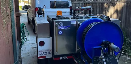 Professional hydro-jetting machine and hose reel mounted on a plumbing service truck.