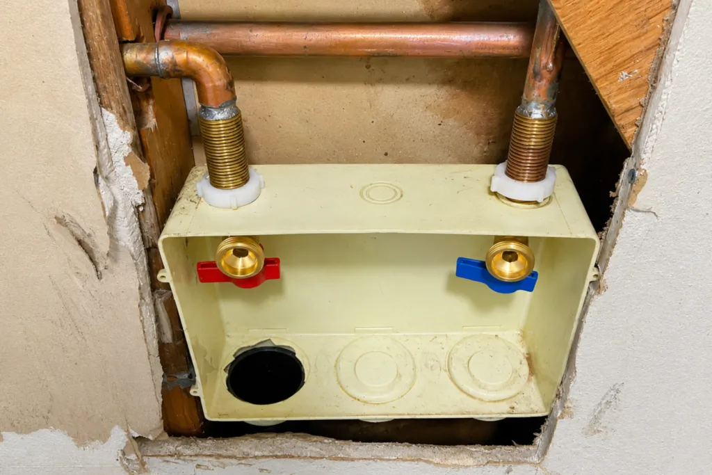 Recessed washing machine water supply valves and drain box installed in a wall
