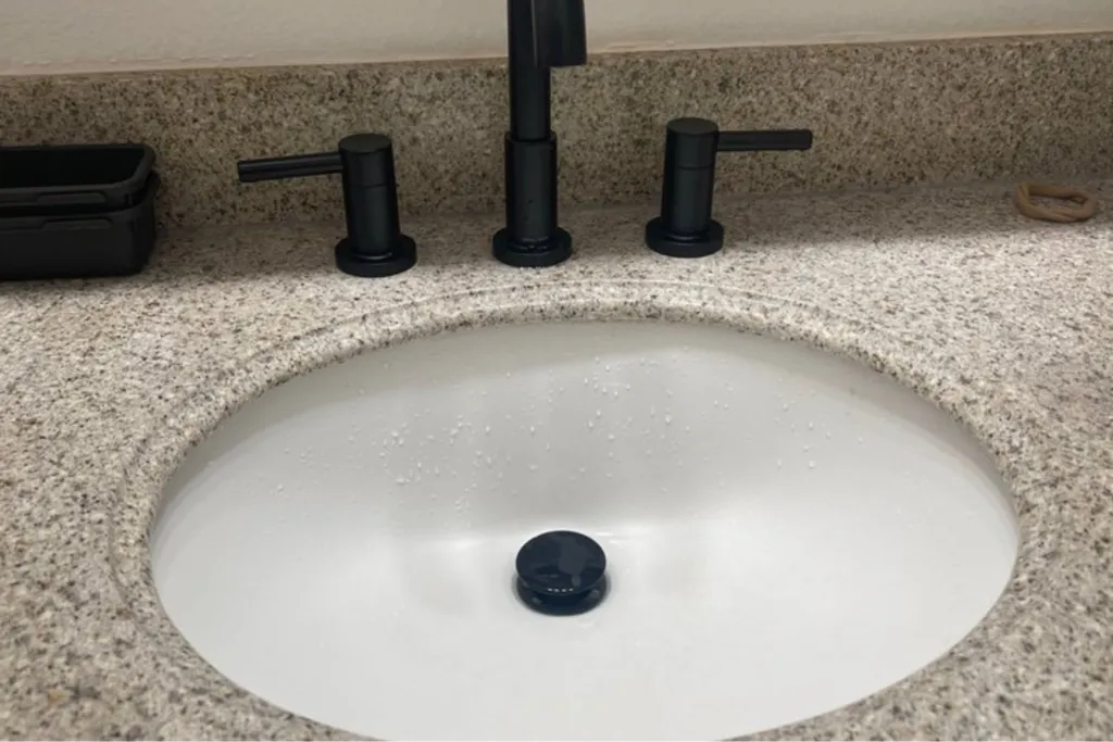 Clean and professionally installed plumbing pipes under a modern bathroom sink.