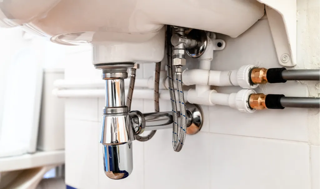 Professionally installed plumbing pipes under a modern bathroom sink