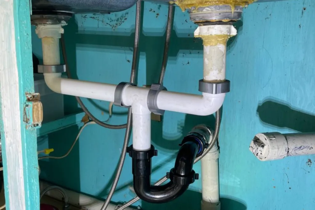 Drainage plumbing professionally installed under a kitchen cabinet sink