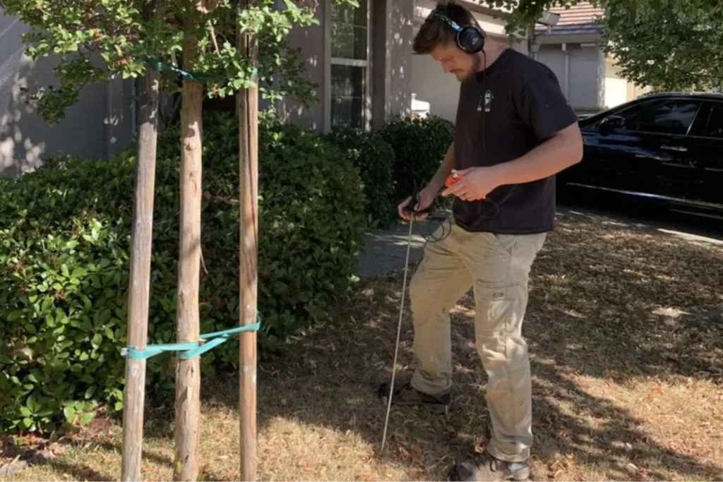 5 Star Plumbing technician using electronic water leak detection equipment in a residential yard to find an underground pipe leak