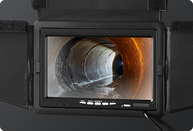 Close-up of a digital monitor showing a pipe interior during a professional residential sewer line camera inspection.