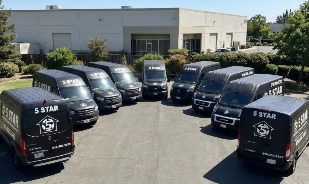 Fleet of black 5 Star Plumbing service vans parked side by side at the company headquarters.